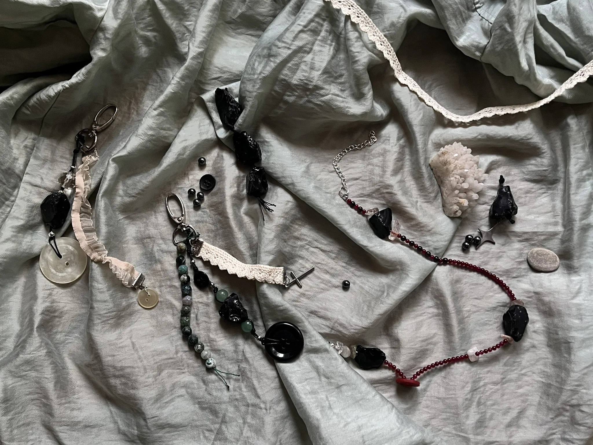Hermit’s Path collection jewelry arranged on pale linen